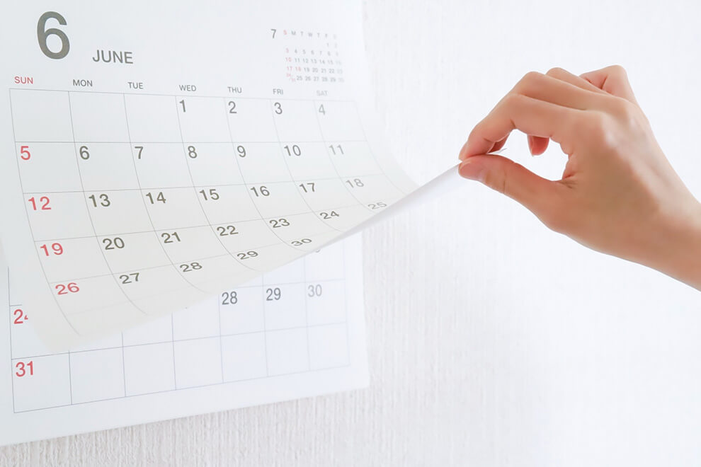 カレンダーをめくって保証期間を確認している手