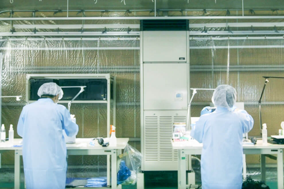 衛生的な環境でパソコンを清掃するスタッフ