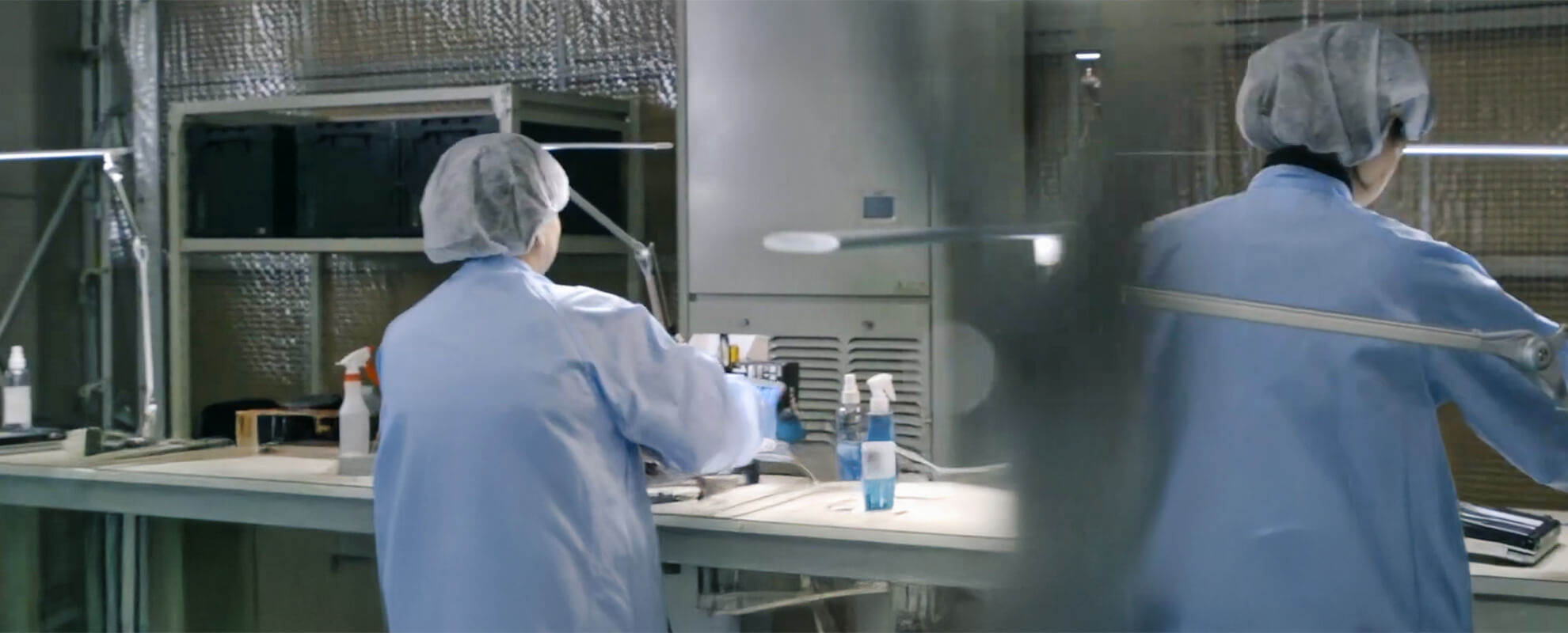 防護服を着用して中古パソコンを清掃するスタッフ